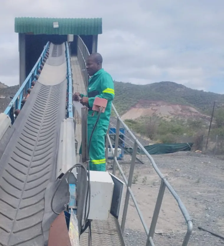 Thibakotse technician inspecting a chevron conveyor belt on a mine site