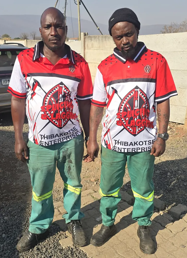 Two Thibakotse technicians in company shirts and workwear